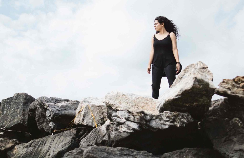 woman standing on rocky hill side