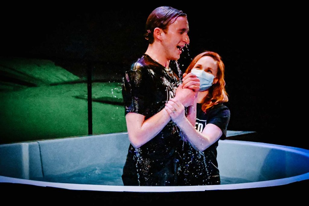 a mother baptizes her teenage son by immersion