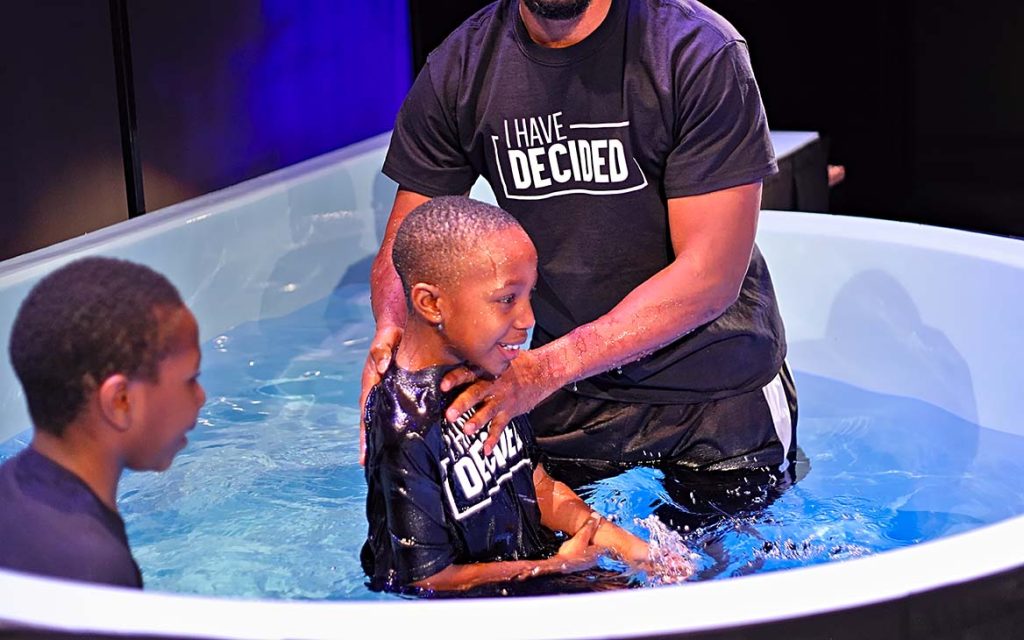 father baptizes his son in water